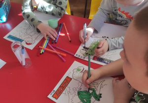 Dzieci kolorują ilustrację z dinozaurem następnie wykonują puzzle składają je